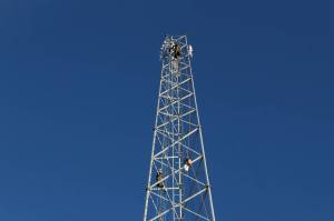 Adam Kiffmeyer and Billy Adamson scale a communications tower on Thursday, Jan. 7 in Nikiski, Alaska. (Ashlyn OHara/Peninsula Clarion)