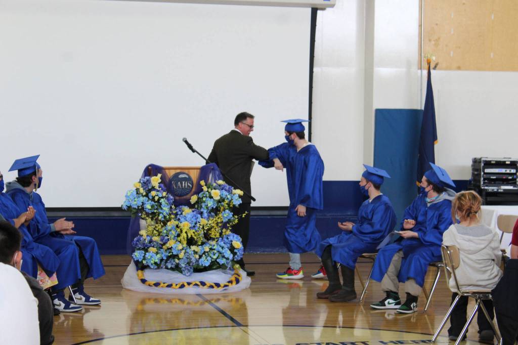 Kenai Alternative High School Principal Loren Reese bumps elbows with graduates during their 2021 graduation ceremony on Tuesday, May 18, 2021 in Kenai, Alaska. (Ashlyn OHara/Peninsula Clarion)