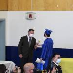 Kenai Alternative High School Principal Loren Reese (left) is given a yellow rose during Kenai Alternative High Schools 2021 graduation ceremony on Tuesday, May 18, 2021 in Kenai, Alaska. (Ashlyn OHara/Peninsula Clarion)