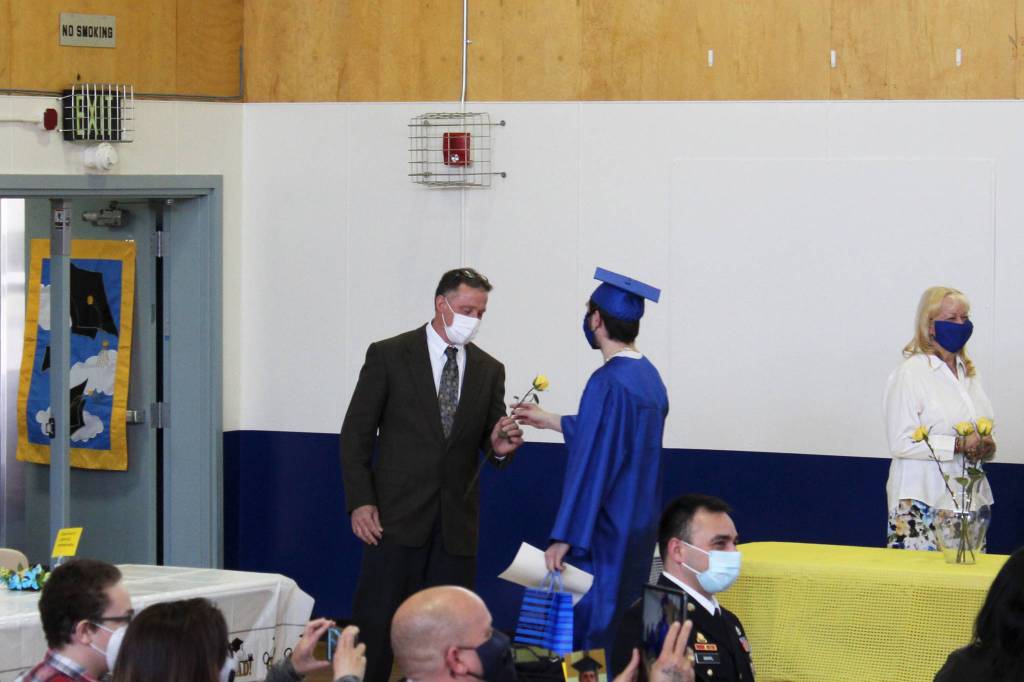 Kenai Alternative High School Principal Loren Reese (left) is given a yellow rose during Kenai Alternative High Schools 2021 graduation ceremony on Tuesday, May 18, 2021 in Kenai, Alaska. (Ashlyn OHara/Peninsula Clarion)