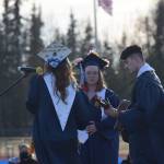 Soldotna High School students Katie Delker, Brittany Lewis and Isaac Nagasako perform at their graduation on Tuesday, May 18, 2021 at the high school football field. (Camille Botello / Peninsula Clarion)