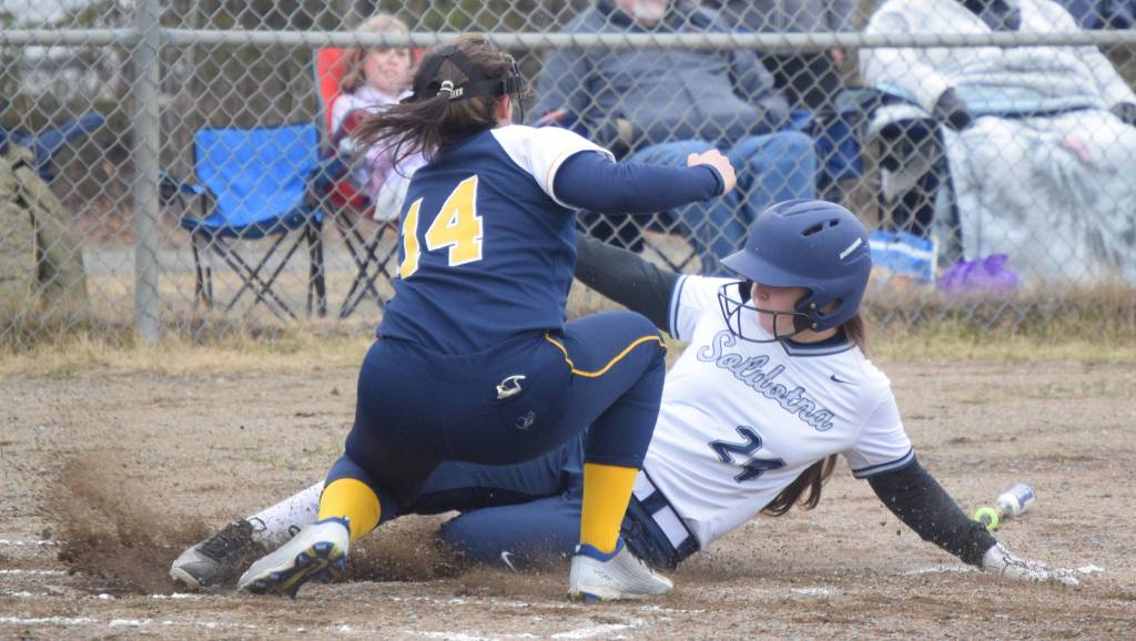 Soldotnas Lexi Stormo slides under the tag of Homer pitcher Zoe Adkins on Thursday, May 20, 2021, in Soldotna, Alaska. (Photo by Jeff Helminiak/Peninsula Clarion)