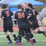 Kenai players mob Leif Lofquist after he scored the game-winning goal in overtime against Homer on Friday, May 21, 2021,in the Peninsula Conference semfinals at Kenai Central High School in Kenai, Alaska. (Photo by Jeff Helminiak/Peninsula Clarion)