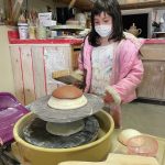 A little visitor at the Jars of Clay studio gets hands-on with the paddle pot demonstration on Saturday, May 15, 2021, at the studio in Homer, Alaska. (Photo by Tara Schmidt)