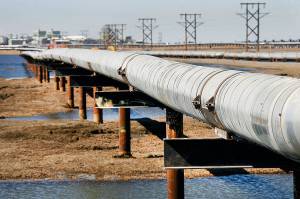 In this 2007 file photo, an oil transit pipeline runs across the tundra to flow station at the Prudhoe Bay oil field on Alaskas North Slope. (AP Photo/Al Grillo, File)