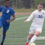 Soldotna's Maleda Denbrock runs to defend Thunder Mountain's Logan Miller at the Division II state championship game in Anchorage, Alaska, on Saturday, May 29, 2021. (Photo by Camille Botello/Peninsula Clarion)