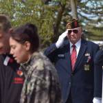 A service member looks on as Kenai High School students Owen Smith and Grace Asi sing the national anthem during the Memorial Day ceremony at Leif Hansen Memorial Park in Kenai, Alaska on Monday, May 31, 2021. (Camille Botello/Peninsula Clarion)