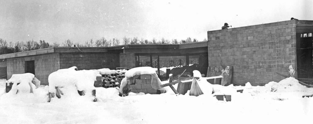 Work on the roof of the new hospital continues during the winter of 1966-67. At this point, the structure is little more than an empty shell built of concrete blocks. (Cheechako News file photo from KPCs Kenai Peninsula Historical Photo Repository)