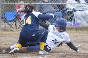 Soldotnas Lexi Stormo slides under the tag of Homer pitcher Zoe Adkins on Thursday, May 20, 2021, in Soldotna, Alaska. (Photo by Jeff Helminiak/Peninsula Clarion)