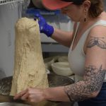 Lucys Market Head Baker Morgan Davie prepares sourdough at the shop in Soldotna, Alaska, on Wednesday, May 26, 2021. The starter is said to have been first cultivated in Germany over 250 years ago. (Camille Botello/Peninsula Clarion)