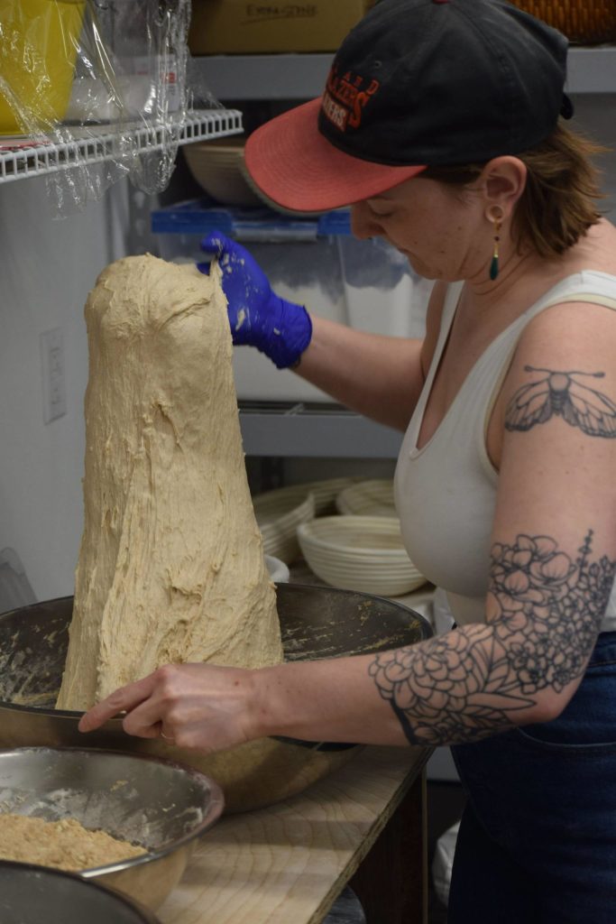 Lucys Market Head Baker Morgan Davie prepares sourdough at the shop in Soldotna, Alaska, on Wednesday, May 26, 2021. The starter is said to have been first cultivated in Germany over 250 years ago. (Camille Botello/Peninsula Clarion)