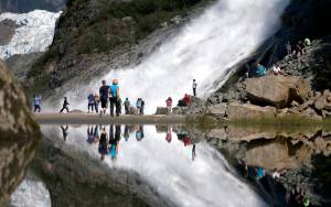 In this July 31, 2013, file photo, tourists visiting the Mendenhall Glacier in the Tongass National Forest are reflected in a pool of water as they make their way to Nugget Falls in Juneau. The federal government has announced plans to repeal or replace a decision by the Trump administration to lift restrictions on logging and road building in a southeast Alaska rainforest that provides habitat for wolves, bears and salmon. The U.S. Department of Agricultures plans for the Tongass National Forest were described as consistent with a January 2021 executive order from President Joe Biden that called for reviewing agency actions during the Trump administration that could be at odds with Bidens environmental priorities. (AP Photo/Charles Rex Arbogast, File)