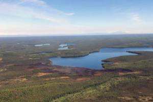 This photo taken at 11:30 a.m. today, Monday, June 14, reveals little smoke rising from the Loon Lake Fire following Sundays aerial attack by water and retardant bombing aircraft. The fire denoted by the burned area at the edge of the lake. (Jason Jordet/Division of Forestry Air Attack)