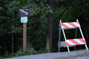 A sign and road blocker at the head of the Hidden Creek Trail on Skilak Lake Road warns people about bear activity on Sunday, June 13, 2021 in Alaska. (Ashlyn OHara/Peninsula Clarion)