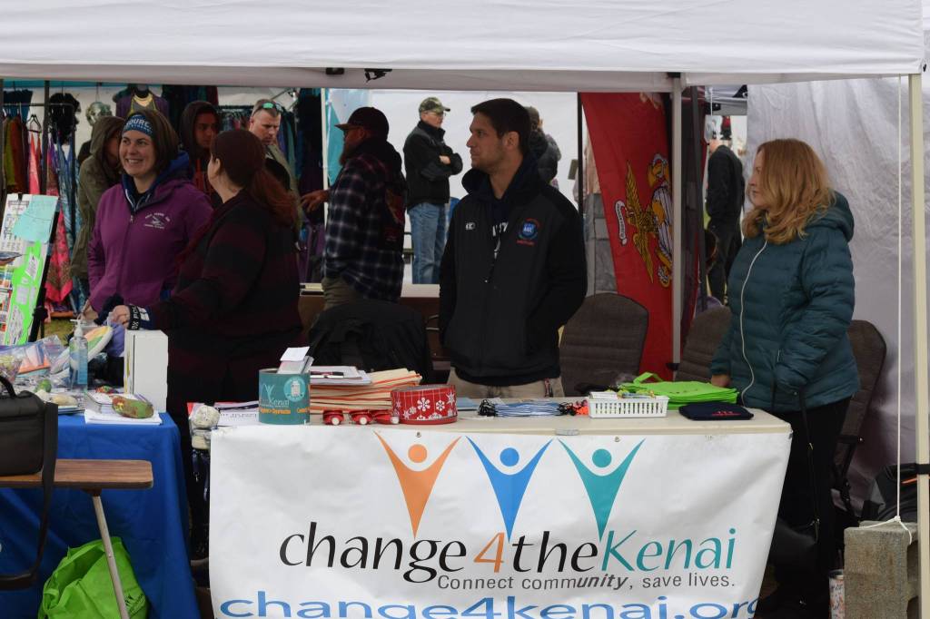 Emily Alvey, an associate, Aaron Gordon and Carline Lew provide information about trauma and adverse childhood experiences at the Soldotna Creek Park Wednesday Market on June 23, 2021. (Camille Botello/Peninsula Clarion)