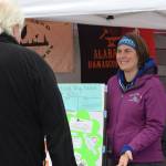Emily Alvey explains the importance of trauma and adverse childhood experience awareness in her booth at the Soldotna Creek Park Wednesday Market on June 23, 2021. (Camille Botello/Peninsula Clarion)