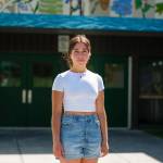 Selma Casagranda, a recent Seward High School graduate and lifelong resident of Seward, stands in front of her former school on May 25, 2021. (Young Kim for The Hechinger Report)