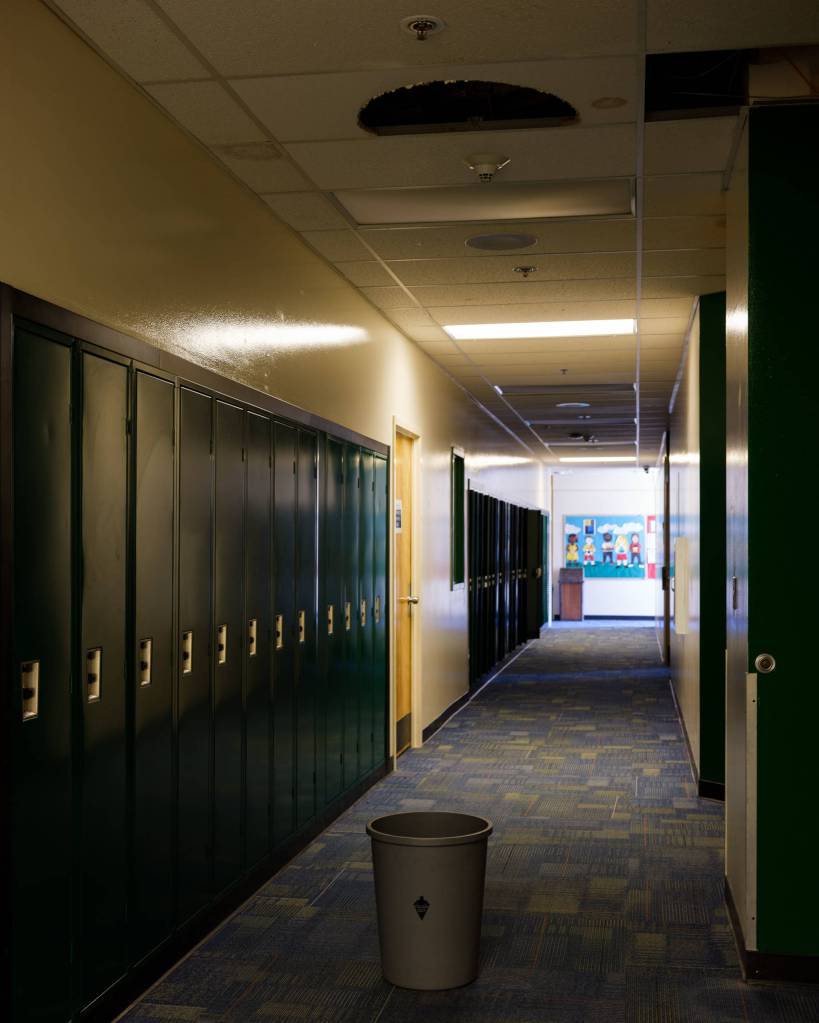 A bucket in a Seward High School hallway catches water when it drips from the ceiling above. This photo was taken on May 25, 2021, which is not during the seasonal torrential rains that come down in Seward, Alaska, each fall. (Young Kim for The Hechinger Report)