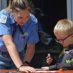 Ranger Meredith Baker helps Fredrick Bryant decorate a fish mobile at the Kenai Wildlife Refuge Visitor Center on July 6, 2021 for Fish Week. (Camille Botello / Peninsula Clarion)