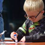 Fredrick Bryant decorates a fish mobile at the Kenai Wildlife Refuge Visitor Center on July 6, 2021 for Fish Week. (Camille Botello / Peninsula Clarion)