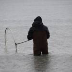 Sol Gaston dipnets on North Kenai Beach on Saturday, July 10, 2021. (Camille Botello/Peninsula Clarion)