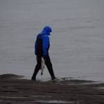 Raymond Bradbury rinses his salmon in the mouth of the Kenai River while dipnetting on Saturday, July 10, 2021. (Camille Botello/Peninsula Clarion)