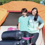 Koebryn and Summer Lazenby stand in front of camping gear at Summer's house on Tuesday, July 13, 2021 near Soldotna, Alaska. (Ashlyn O'Hara/Peninsula Clarion)