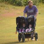Rustin Hitchcock races daughters Talya, 2, and Aida, 10 months, to victory in the 5-kilometer event at the Rotary Unity Run at Tsalteshi Trails just outside of Soldotna, Alaska, on Saturday, July 17, 2021. (Photo by Jeff Helminiak/Peninsula Clarion)