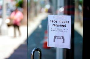 FILE - A sign advises shoppers to wear masks outside of a store Monday, July 19, 2021, in the Fairfax district of Los Angeles. Infections are climbing across the U.S. and mask mandates and other COVID-19 prevention measures are making a comeback in some places as health officials issue increasingly dire warnings about the highly contagious delta variant. But in a possible sign that the warnings are getting through to more Americans, vaccination rates are creeping up again, offering hope that the nation could yet break free of the coronavirus if people who have been reluctant to receive the shot are finally inoculated. (AP Photo/Marcio Jose Sanchez, File)