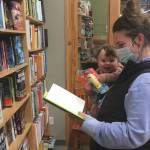 Jessie Duke, of Soldotna, browses books with 7-month-old Danny Dommek on Monday, Nov. 16, 2020, at River City Books in Soldotna, Alaska. (Photo by Jeff Helminiak/Peninsula Clarion)