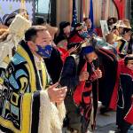 Rico Worl, foreground left, dances during a ceremony on Friday, July 30, 2021, in Juneau, Alaska, that marked the release of a stamp he created for the U.S. Postal Service. Worl, an Alaska Native artist, has said he hopes the Raven Story stamp will be a gateway for people to learn about his Tlingit culture. (AP Photo/Becky Bohrer)