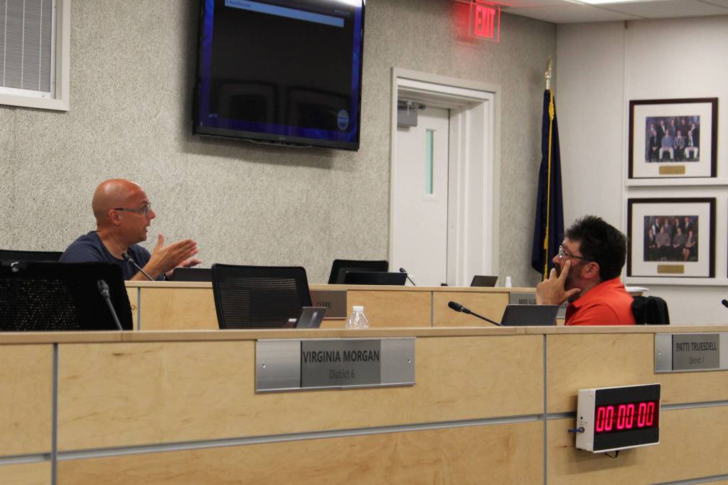 Board members Jason Tauriainen and Matt Morse discuss the COVID-19 vaccine during a break at a meeting of the Kenai Peninsula Borough School District Board of Education on Monday, Aug. 2, 2021 in Soldotna, Alaska. (Ashlyn OHara/Peninsula Clarion)