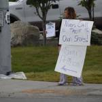 A demonstrator stands at the Y intersection of the Kenai Spur and Sterling highways in Soldotna on Saturday, Aug. 14 to protest mandatory COVID-19 vaccines and mitigation protocols. (Camille Botello/Peninsula Clarion)