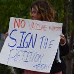 A demonstrator stands at the Y intersection of the Kenai Spur and Sterling highways in Soldotna on Saturday, Aug. 14 to protest mandatory COVID-19 vaccines and mitigation protocols. (Camille Botello/Peninsula Clarion)