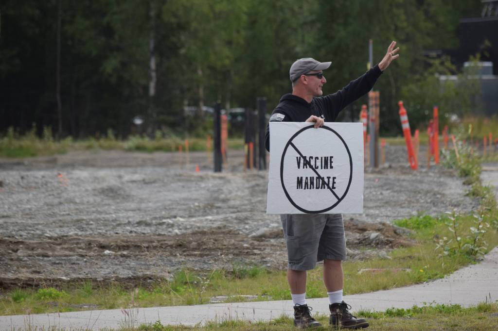 A demonstrator stands at the Y intersection of the Kenai Spur and Sterling highways in Soldotna on Saturday, Aug. 14 to protest mandatory COVID-19 vaccines and mitigation protocols. (Camille Botello/Peninsula Clarion)