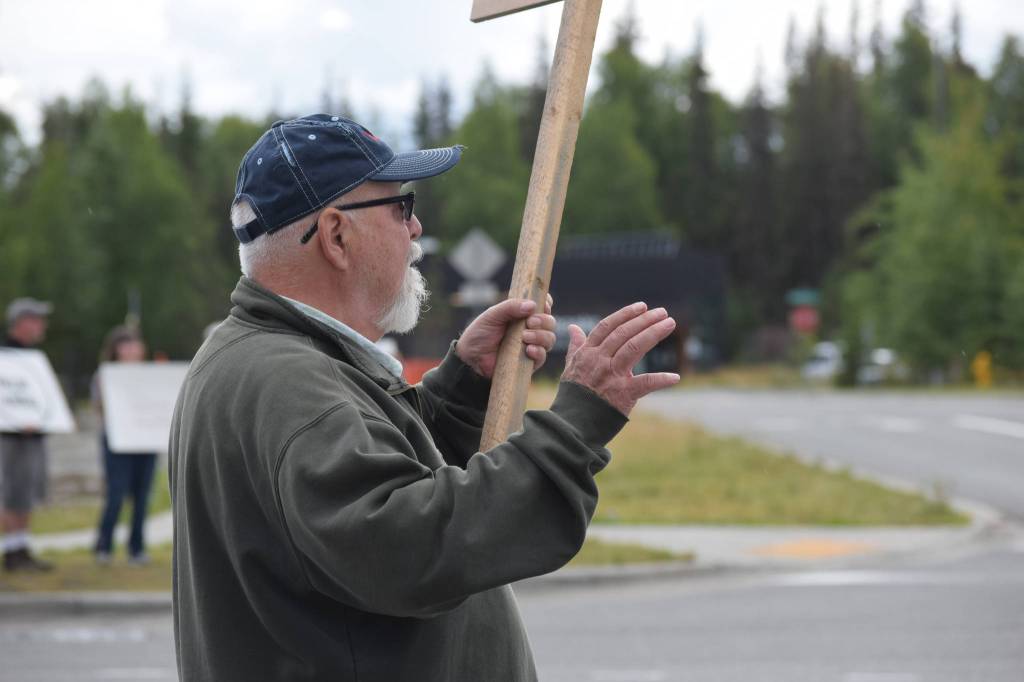 Kevin Hall stands at the Y intersection of the Kenai Spur and Sterling highways in Soldotna on Saturday, Aug. 14 to protest mandatory COVID-19 vaccines and mitigation protocols. (Camille Botello/Peninsula Clarion)