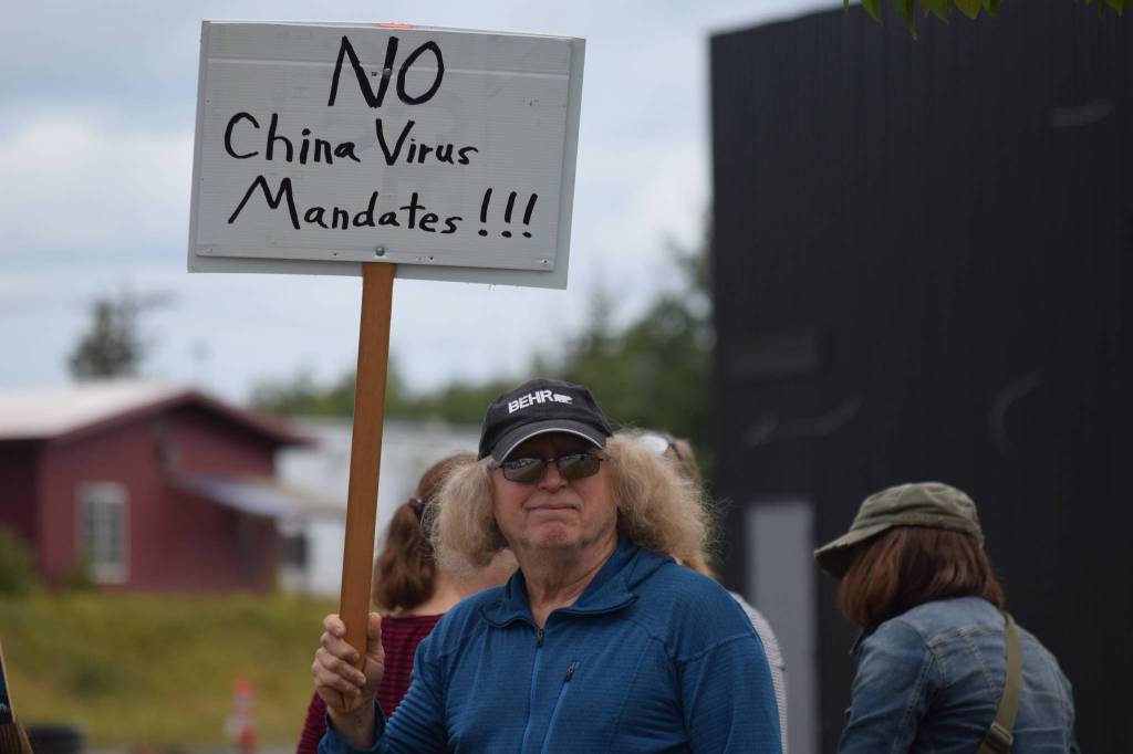 A demonstrator stands at the Y intersection of the Kenai Spur and Sterling highways in Soldotna on Saturday, Aug. 14 to protest mandatory COVID-19 vaccines and mitigation protocols. (Camille Botello/Peninsula Clarion)
