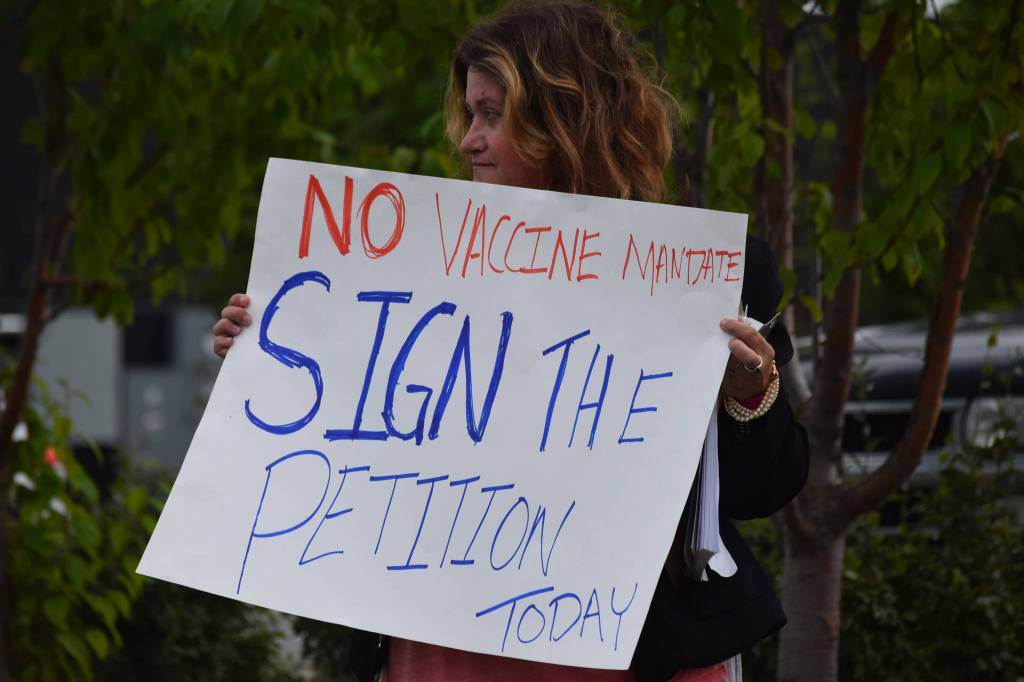 A demonstrator stands at the Y intersection of the Kenai Spur and Sterling highways in Soldotna on Saturday, Aug. 14 to protest mandatory COVID-19 vaccines and mitigation protocols. (Camille Botello/Peninsula Clarion)
