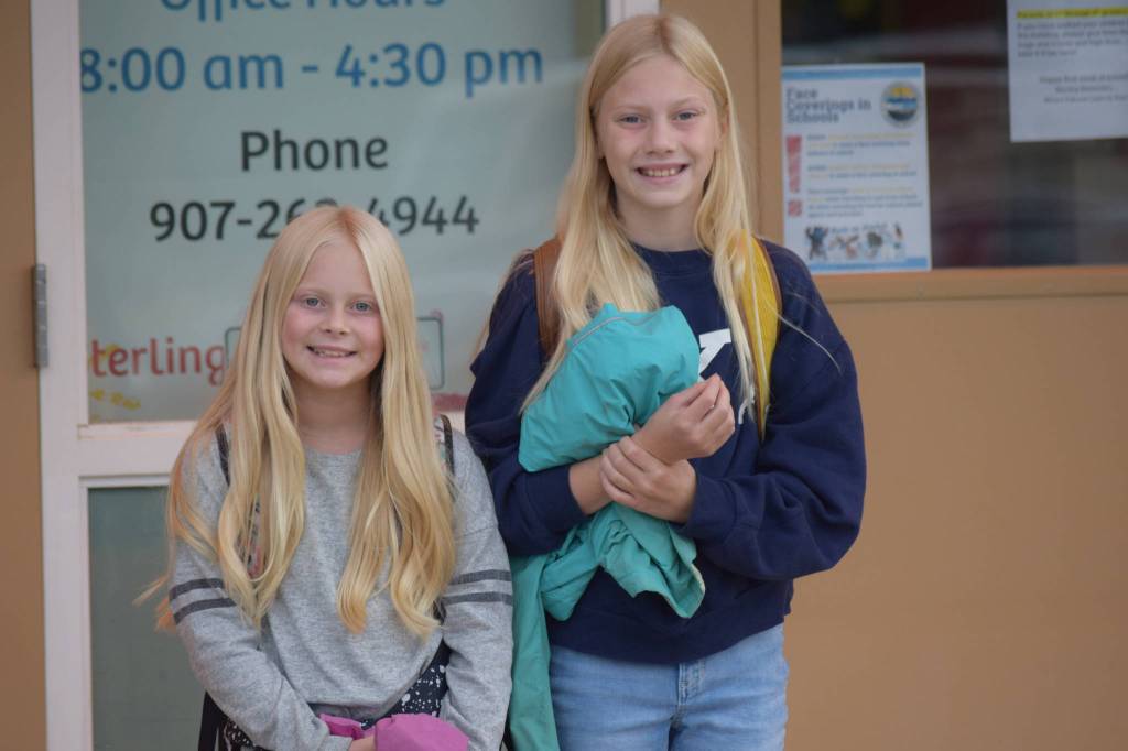 Tynlee, fourth grade, and Taylen Moore, sixth grade, head into Sterling Elementary on their first day of school on Tuesday, August 17, 2021. (Camille Botello / Peninsula Clarion)