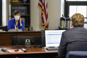 Rep. Ivy Sponholz, D-Anchorage, left, listens as Legislative Finance Director Alexei Painter gives a presentation to the House Ways and Means Committee on Monday, Aug. 23, 2021. Lawmakers have less than 30 days to try and both complete the states budget and find resolution on the states long term fiscal problems. (Peter Segall / Juneau Empire)