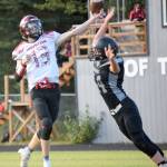 Houston quarterback Colton Bunn gets off a pass under pressure from Nikiskis Truit McCaughey on Friday, Aug. 27, 2021, at Nikiski High School in Nikiski, Alaska. (Photo by Jeff Helminiak/Peninsula Clarion)