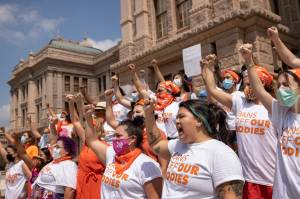 In this Sept. 1, 2021 file photo, women protest against the six-week abortion ban at the Capitol in Austin, Texas. Even before a strict abortion ban took effect in Texas this week, clinics in neighboring states were fielding more and more calls from women desperate for options. The Texas law, allowed to stand in a decision Thursday, Sept. 2, 2021 by the U.S. Supreme Court, bans abortions after a fetal heartbeat can be detected, typically around six weeks. (Jay Janner/Austin American-Statesman via AP File)
