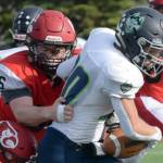 Redington's Jaden Spaulding slips between two Kardinals for a gain Saturday, Sept. 11, 2021, at Kenai Central High School in Kenai, Alaska. (Photo by Jeff Helminiak/Peninsula Clarion)