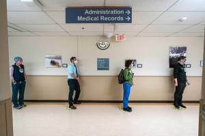 In this Wednesday, Dec. 16, 2020, file photo, front-line caregivers wait in line to receive a Pfizer COVID-19 vaccine at Providence Alaska Medical Center in Anchorage, Alaska. Overwhelmed by a surge in COVID-19 patients, Providence Alaska Medical Center, Alaskas largest hospital, on Tuesday, Sept. 14, 2021, implemented crisis standards of care, prioritizing resources and treatments to those patients who have the potential to benefit the most. (Loren Holmes/Anchorage Daily News via AP, File)