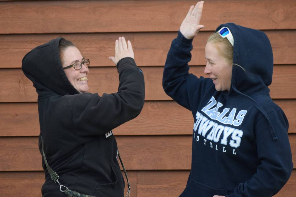 Angela Covey, left, high-fives her friend after winning the Kenai River Silver Salmon Derby at the Kenai Chamber of Commerce and Visitor Center on Monday, Sept. 20, 2021. (Camille Botello/Peninsula Clarion)