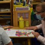 Everett Anderson, second grade, shows Principal John DeVolld some of his class work at Soldotna Montessori Charter School on Tuesday, Sept. 21, 2021. (Camille Botello/Peninsula Clarion)