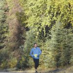 Womens half marathon winner Meghan Cloud is awash in fall colors during the Kenai River Marathon in Kenai, Alaska, on Sunday, Sept. 26, 2021. (Photo by Jeff Helminiak/Peninsula Clarion)