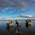Ben Stevens scans the shore for signs of moose while heading up the Yukon River to the Stevens Family hunting camp on Tuesday, Sept. 14, 2021, near Stevens Village, Alaska. For the first time in memory, both king and chum salmon have dwindled to almost nothing and the state has banned salmon fishing on the Yukon. The remote communities that dot the river and live off its bounty are desperate and doubling down on moose and caribou hunts in the waning days of fall. (AP Photo/Nathan Howard)