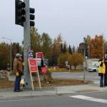 People waive signs at the intersection of Kenai Spur Highway and Main Street Loop on Tuesday, Oct. 5, 2021 in Kenai, Alaska.(Ashlyn OHara/Peninsula Clarion)