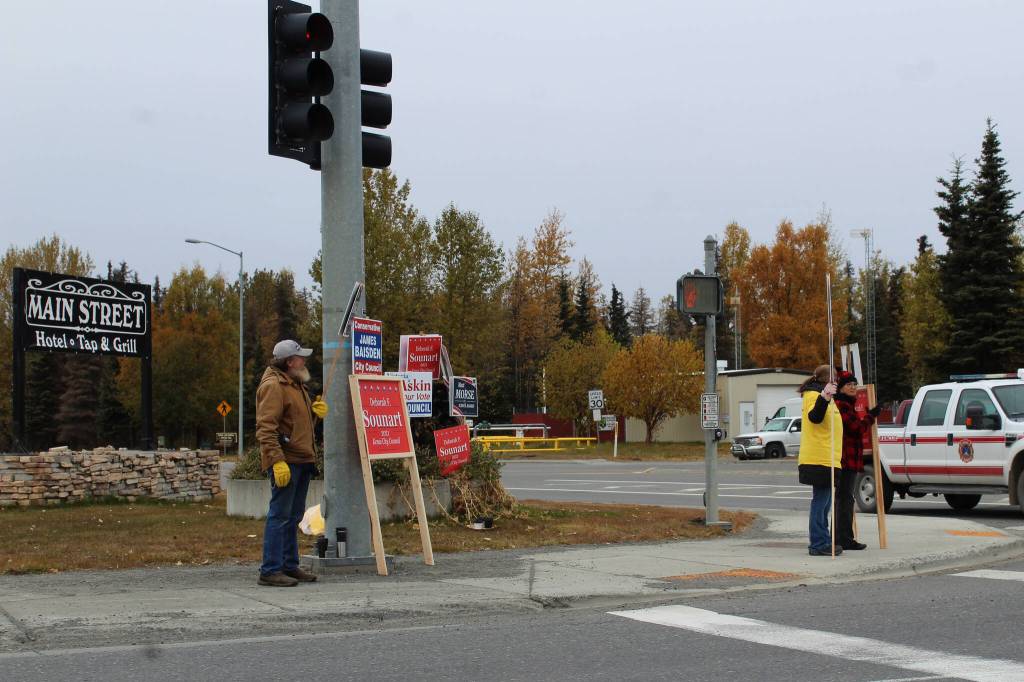 People waive signs at the intersection of Kenai Spur Highway and Main Street Loop on Tuesday, Oct. 5, 2021 in Kenai, Alaska.(Ashlyn OHara/Peninsula Clarion)